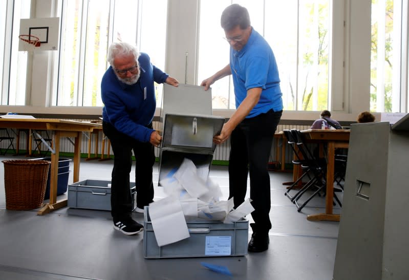 Members of the district election office Stadtkreis 3 empty a ballot box in Zurich