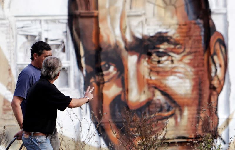 FILE PHOTO: A man gestures towards a pre-election mural, depicting TOP09 political party chairman Schwarzenberg, painted on an abandoned building in Prague