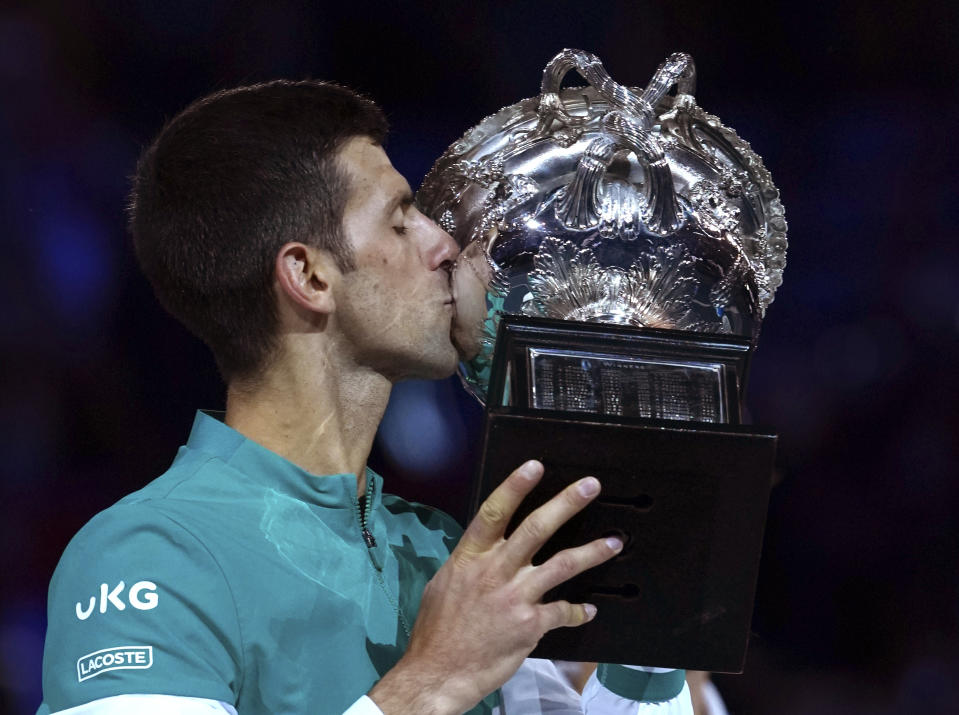 Serbia's Novak Djokovic kisses the Norman Brookes Challenge Cup after defeating Russia's Daniil Medvedev in the men's singles final at the Australian Open tennis championship in Melbourne, Australia, Sunday, Feb. 21, 2021.(AP Photo/Mark Dadswell)