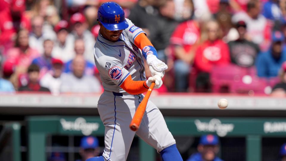 New York Mets shortstop Francisco Lindor (12) hits a double in the first inning of an MLB baseball game against the Cincinnati Reds, Sunday, April 7, 2024, at Great American Ball Park in Cincinnati.