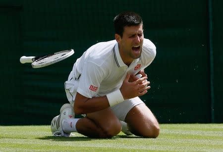 Novak Djokovic from Serbia falls during his men's singles match against Gilles Simon from France at the Wimbledon Tennis Championships, in London June 27, 2014. REUTERS/Stefan Wermuth