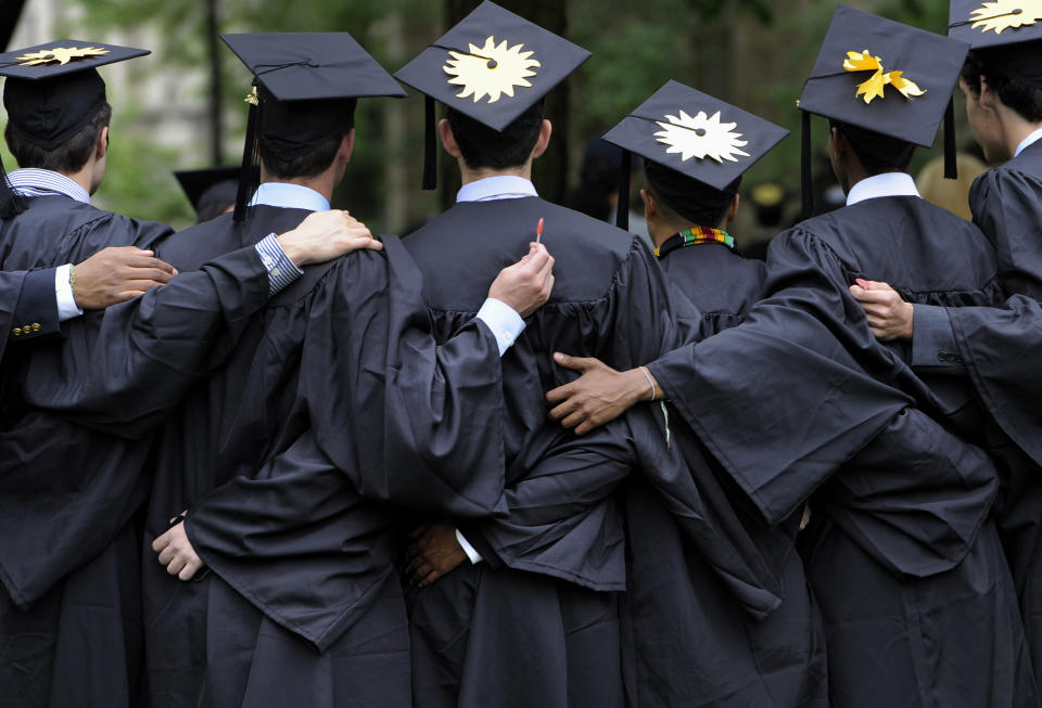 Graduates pose for photographs during commencement at Yale University in New Haven, Conn. There's still plenty of pomp and circumstance, inspiring words from lofty speakers and tossing tassels, but today's college graduation ceremonies include many a contemporary twist. In 1984, according to some estimates, only half of graduates had debt from college loans, averaging about $2,000. Now, two-thirds of recent bachelor's degree recipients have outstanding student loans, with an average debt of about $27,000, according to a Pew Research Center report. (AP Photo/Jessica Hill, File)