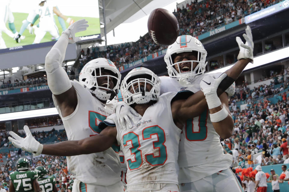 Miami Dolphins' outside linebacker Jerome Baker (55) cornerback Jomal Wiltz (33) and defensive back Nik Needham (40) celebrate after Wiltz made an interception during the first half of an NFL football game against the New York Jets, Sunday, Nov. 3, 2019, in Miami Gardens, Fla. (AP Photo/Lynne Sladky)