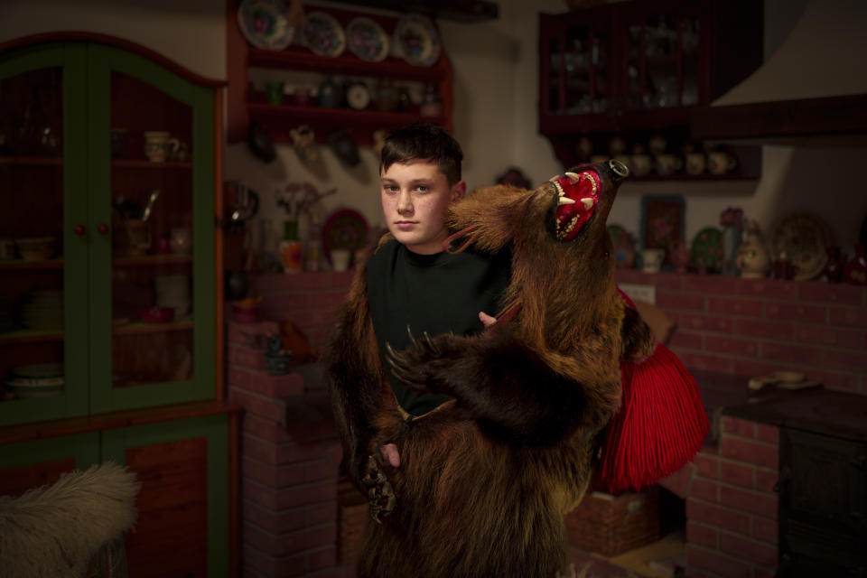 David, 13 years-old, a member of the Sipoteni bear pack, poses for a portrait in Comanesti, northern Romania, Wednesday, Dec. 27, 2023. David first wore the bear fur costume when he was 5 years-old and is proud to be a part of a centuries old tradition. (AP Photo/Andreea Alexandru)