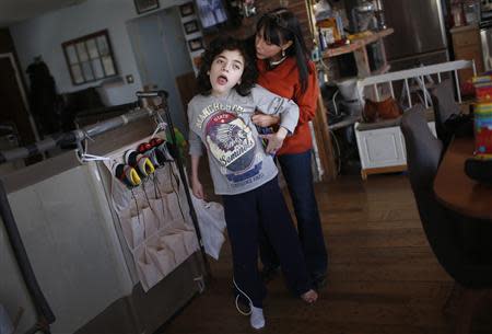 Missy Miller (R) holds her epileptic son Oliver in their home at Atlantic Beach, New York January 7, 2014. REUTERS/Mike Segar
