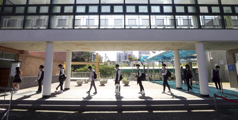 Senior students maintain a social distance as they arrival at Hamwol High School in Ulsan, South Korea, Wednesday, May 20, 2020. South Korean students began returning to schools Wednesday as their country prepares for a new normal amid the coronavirus pandemic. (Kim Yong-tae/Yonhap via AP)