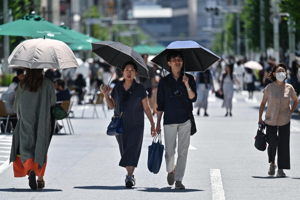 Pedestrians shelter from the sun as the summer heat returns across the country, in the Ginza area of Tokyo on June 16, 2024. (Photo by Richard A. Brooks / AFP) (Photo by RICHARD A. BROOKS/AFP via Getty Images)