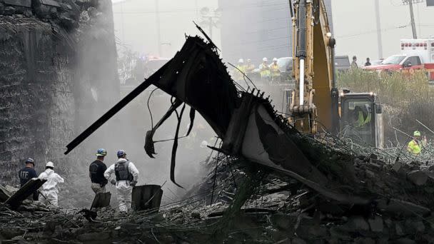 PHOTO: Workers inspect and clear debris from a section of the bridge that collapsed on Interstate 95 after an oil tanker explosion on June 12, 2023 in Philadelphia. (Mark Makela/Getty Images)