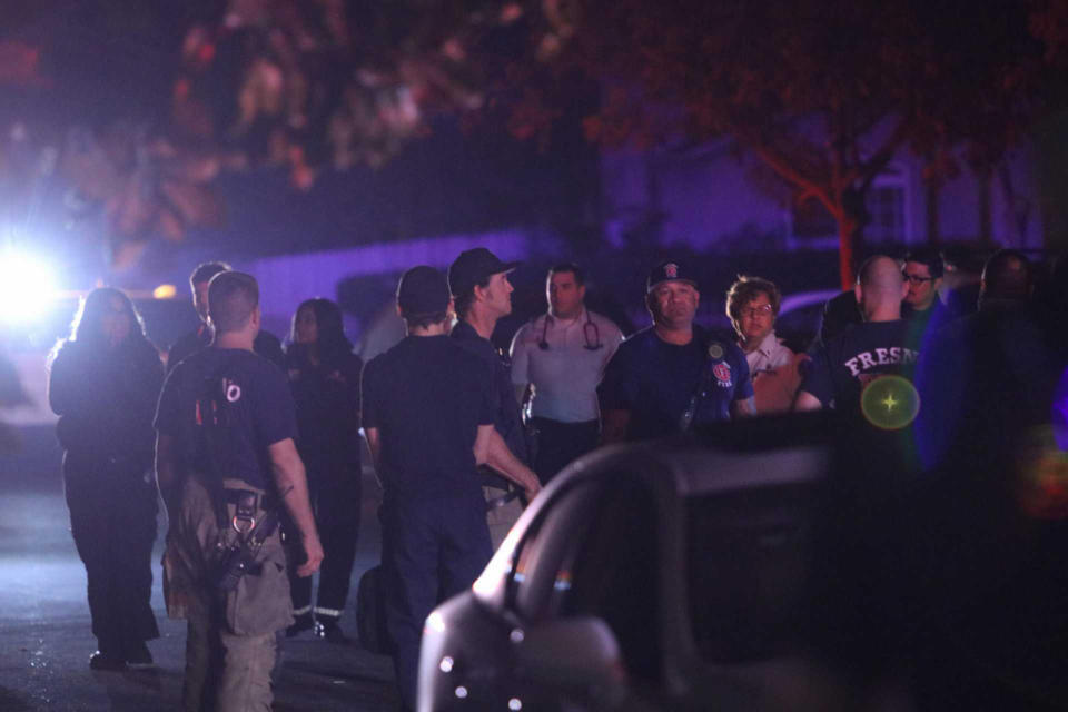 Police and emergency personnel are on the scene of a shooting at a backyard party, Sunday, Nov. 17, 2019, in southeast Fresno, Calif. Multiple people were shot and at least four of them were killed Sunday at a party in Fresno when suspects sneaked into the backyard and fired into the crowd, police said. (Larry Valenzuela//The Fresno Bee via AP)