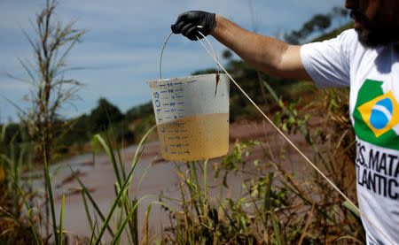 A member of SOS Mata Atlantica Foundation collects samples as they start an expedition on the Paraopeba River to understand the environmental impact of the mudslide after a tailings dam owned by Brazilian mining company Vale SA collapsed, in Brumadinho, Brazil January 31, 2019. REUTERS/Adriano Machado