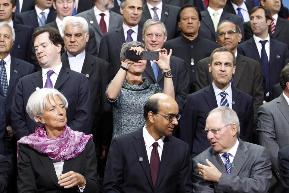 International Monetary and Financial Committee leaders pose for group photo during the IMF/World Bank spring meetings in Washington Saturday, April, 21, 2012. They are from left front IMF Managing Director Christine Lagarde, Singapore Finance Minister Tharman Shanmugaratnam, and German Finance Minister Wolfgang Schaeuble. Behind them taking a picture is Denmark's Deputy Prime Minister and Minister for Economic Affairs Margrethe Vestager. (AP Photo/Jose Luis Magana)