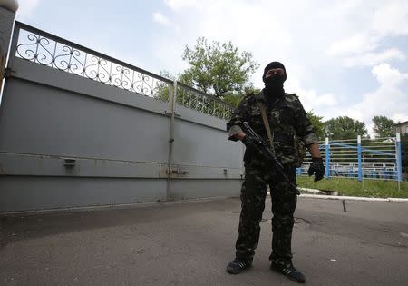 A pro-Russian separatist stands guard near the gates of a base in the east Ukrainian city of Donetsk May 30, 2014. REUTERS/Maxim Zmeyev