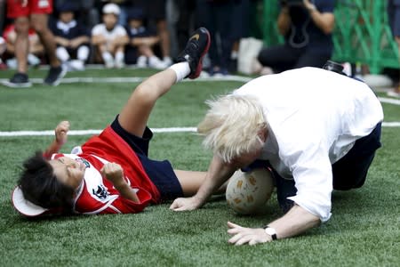 London's Mayor Boris Johnson falls down after colliding with 10-year-old Toki Sekiguchi in Tokyo