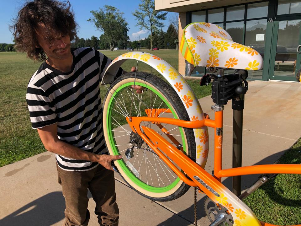 Volunteer Anton Getz works on a colorful bike outside at the South Bend Bike Garage at Indiana 933 and Angela Boulevard on July 13, 2022.