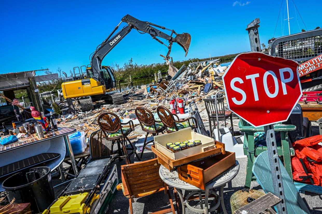 Workers clearing debris in Fort Myers, Fla., in the wake of Hurricane Ian