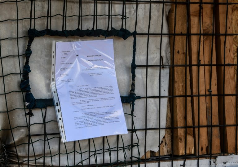 This photo taken on October 17, 2016 shows an eviction letter posted by French government authorities calling for the evacuation of the "Jungle" migrant and refugee encampment in Calais before dismantlement of the site