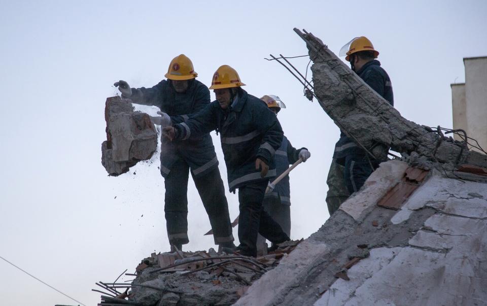 Rescuers remove debris from a damaged building in Durres, western Albania, Wednesday, Nov. 27, 2019. The death toll from a powerful earthquake in Albania has risen to 25 overnight as local and international rescue crews continue to search collapsed buildings for survivors. (AP Photo/Visar Kryeziu)