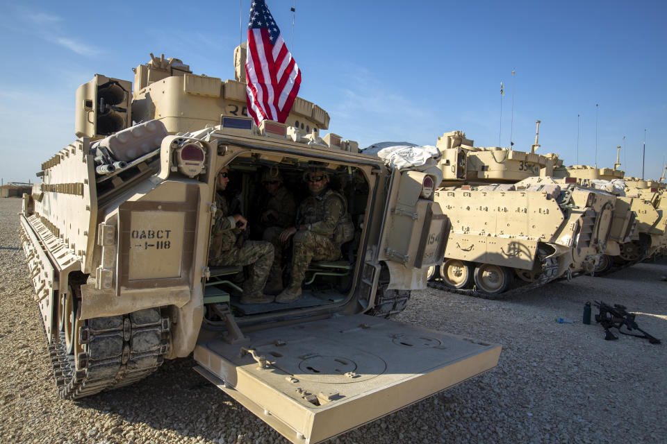 Crewmen sit inside Bradley fighting vehicles at a US military base at an undisclosed location in Northeastern Syria, Monday, Nov. 11, 2019. The deployment of the mechanized force comes after US troops withdrew from northeastern Syria, making way for a Turkish offensive that began last month. (AP Photo/Darko Bandic)