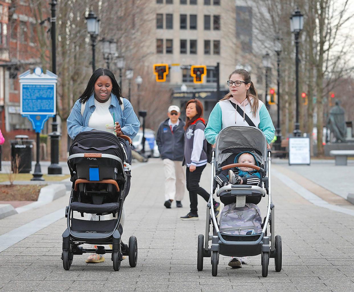 Amelia Williams and her 3-month-old son Callum stroll with Caitlin Connolly and her 20-month-old son Carson. Warm weather got people outside and moving in Quincy on Thursday, Feb. 16, 2023.
