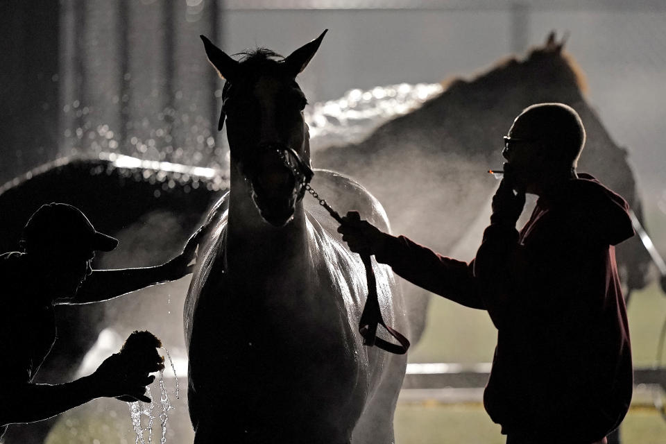 A horse gets a bath after an early morning workout at Churchill Downs Friday, May 6, 2022, in Louisville, Ky. The 148th running of the Kentucky Derby is scheduled for Saturday, May 7. (AP Photo/Charlie Riedel)