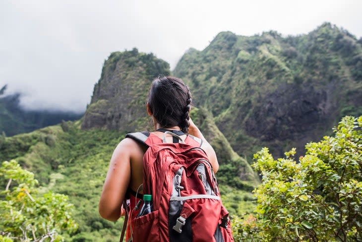 Hiker stopping to enjoy rainforest, Iao Valley, Maui, Hawaii