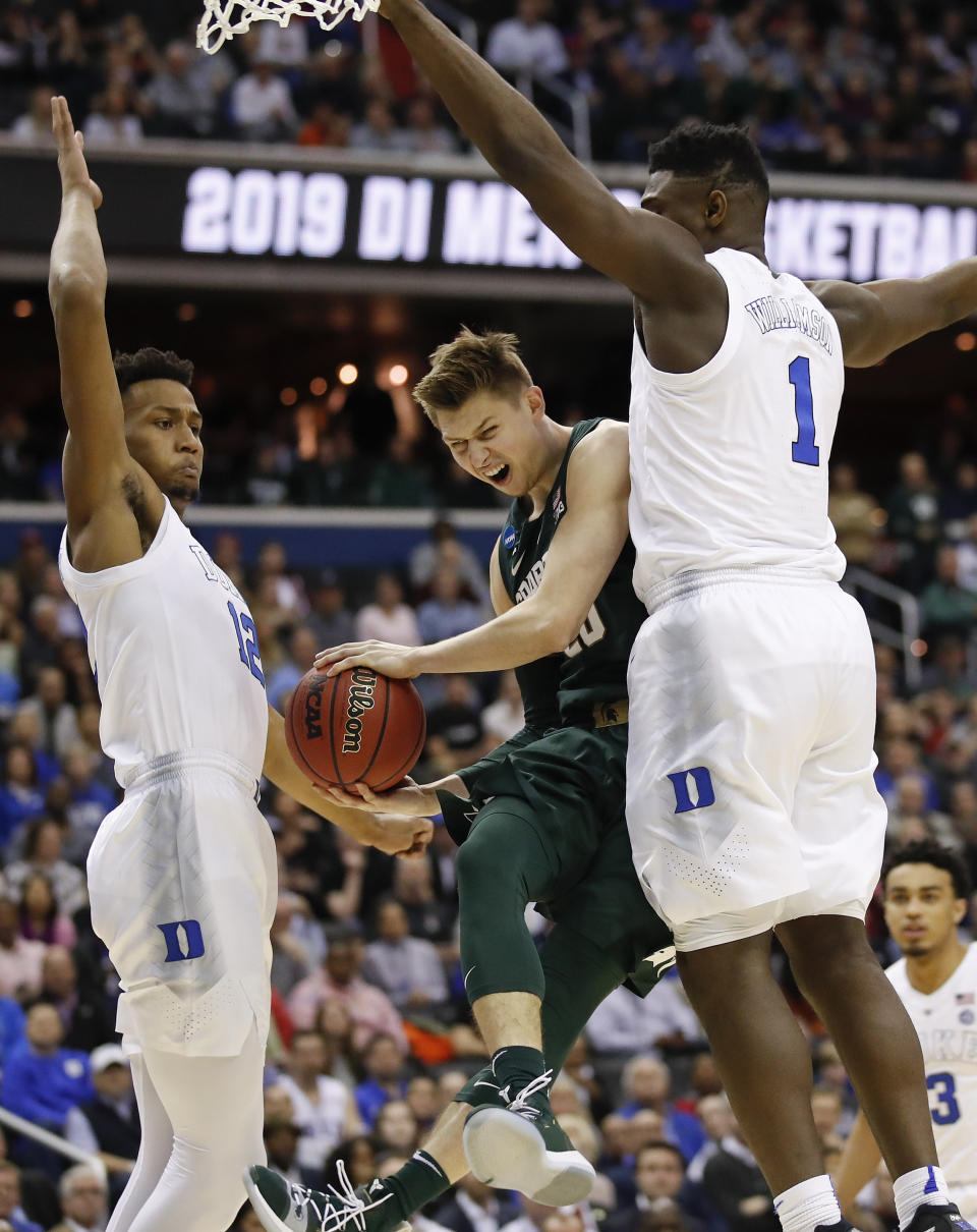 Michigan State guard Matt McQuaid (20) is stopped under the basket by Duke forwards Zion Williamson (1) and Javin DeLaurier (12) during the first half of an NCAA men's East Regional final college basketball game in Washington, Sunday, March 31, 2019. (AP Photo/Alex Brandon)
