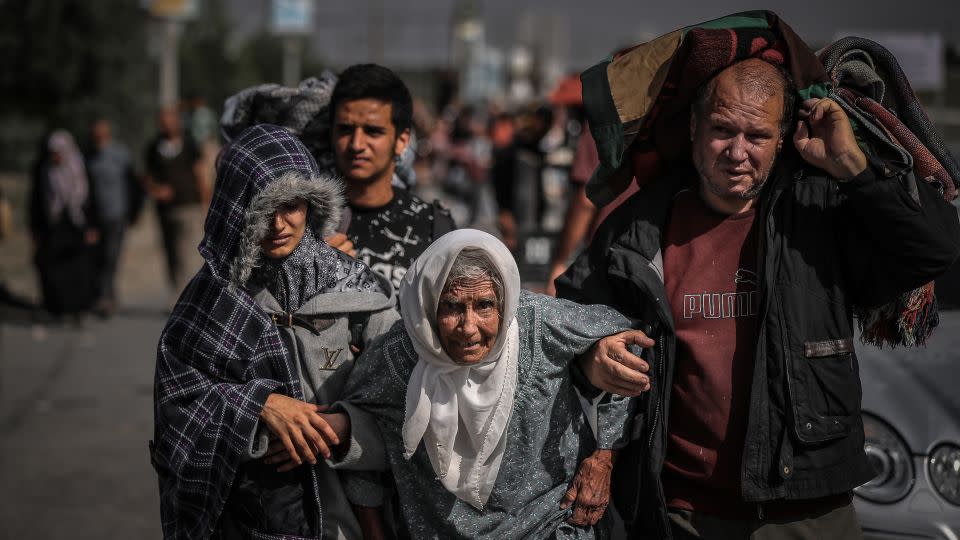 Palestinians help an elderly woman, as Israel's military offensive forces them to flee from northern Gaza, on November 10. Older Gazans are among those most at risk of severe hunger, illness, injury and death. - Belal Khaled/Anadolu/Getty Images