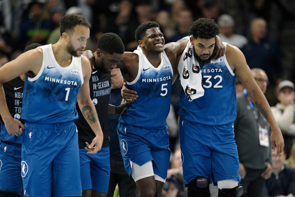 Minnesota Timberwolves guard Anthony Edwards (5) is helped off the court after sustaining an injury during the second half of an NBA basketball In-Season Tournament game against the Oklahoma City Thunder, Tuesday, Nov. 28, 2023, in Minneapolis. (AP Photo/Abbie Parr)