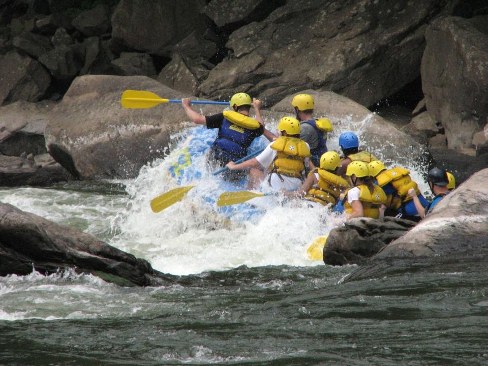 Whitewater rafters navigate Fayette Station rapids at New River Gorge.