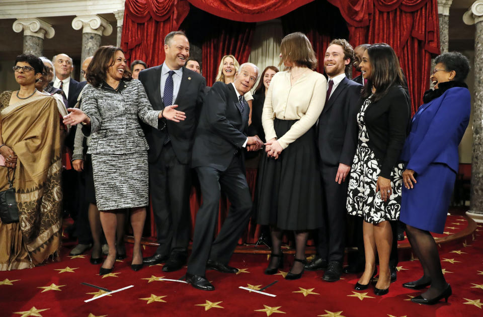 FILE - In this Jan. 3, 2017, file photo, then-Vice President Joe Biden, center, ducks down so all of the family of then-Sen. Kamala Harris, D-Calif., second from right, can be seen for a group photo during a mock swearing in ceremony in the Old Senate Chamber on Capitol Hill in Washington. (AP Photo/Alex Brandon, File)