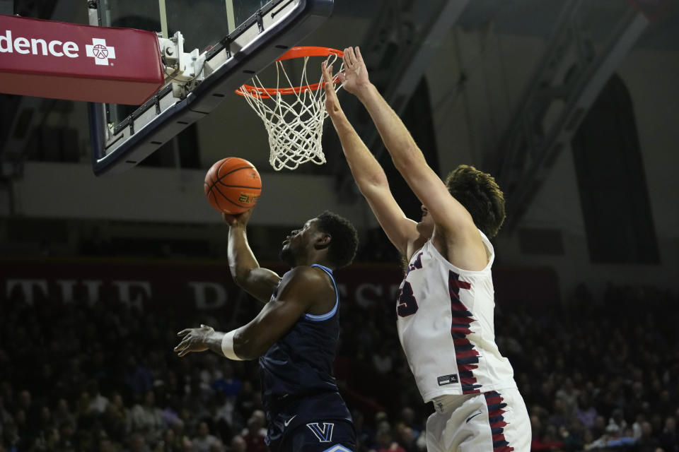 Villanova's TJ Bamba, left, goes up for a shot past Pennsylvania's Nick Spinoso during the first half of an NCAA college basketball game, Monday, Nov. 13, 2023, in Philadelphia. (AP Photo/Matt Slocum)