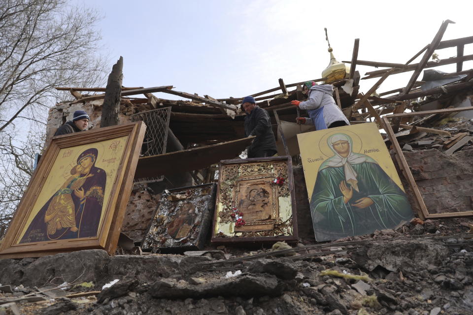 CAPTION CORRECTS TOWN SPELLING - People save icons as they clear the rubble after a Russian rocket ruined an Orthodox church in rocket attack on Easter night, a crater left by the rocket in the foreground, in Komyshuvakha, Zaporizhzhia region, Ukraine, early hours Sunday, April 16, 2023. (AP Photo/Kateryna Klochko)