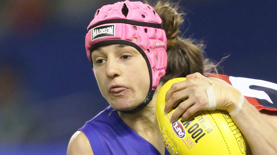Seen here, former AFLW star Heather Anderson getting tackled with the footy.