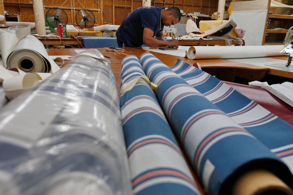 Anthony Pena etches the template for a new section of upholstery at Cesar Marine Canvas & Upholstery on Harbor Street in New Bedford.