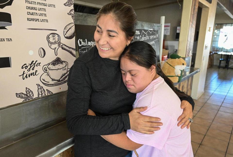Evelyn Gutierrez-Macedo, owner of Mi Cafesito, hugs her niece, Diana Gutierrez, while at the cafe’s new location at Van Ness and Home avenues in the Tower District.