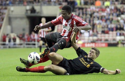 Sunderland's midfielder Stephane Sessegnon (L) is tackled by Liverpool's midfielder Steven Gerrard during the English Premier League football match at The Stadium of Light in Sunderland