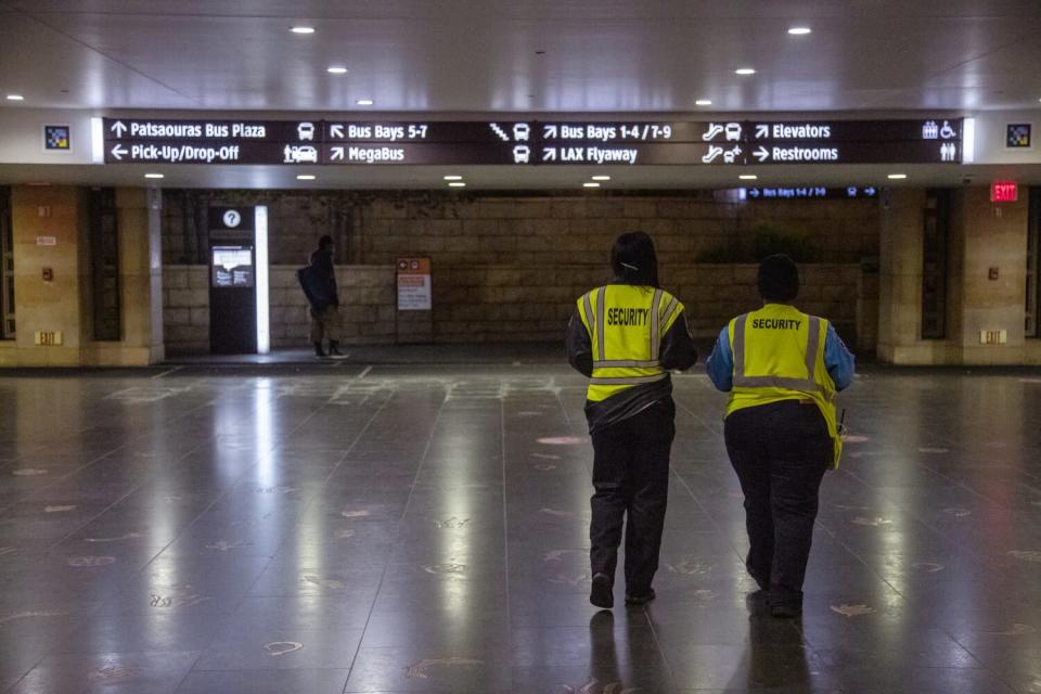 Security personnel in neon yellow vests walk through Union Station