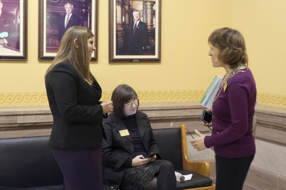 Anti-abortion lobbyists from left, Brittany Jones, of the Family Policy Alliance of Kansas; Jeannette Pryor, of the Kansas Catholic Conference, and Jeanne Gawdun, of Kansans for Life, confer outside the state Senate chamber ahead of a debate on a proposed constitutional amendment on abortion, Wednesday, Jan. 29. 2020, at the Statehouse in Topeka, Kansas. The amendment would overturn a Kansas Supreme Court decision protecting abortion rights. (AP Photo/John Hanna)