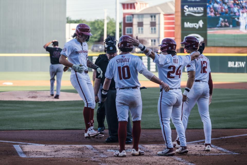 Arkansas baseball's Wehiwa Aloy (left) celebrates with teammates after hitting a grand slam in the Hogs' 11-7 win over Missouri State Tuesday, April 30, 2024.