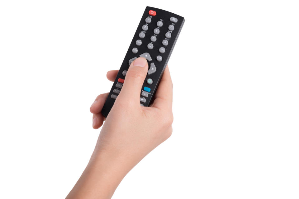 A hand holding a remote control