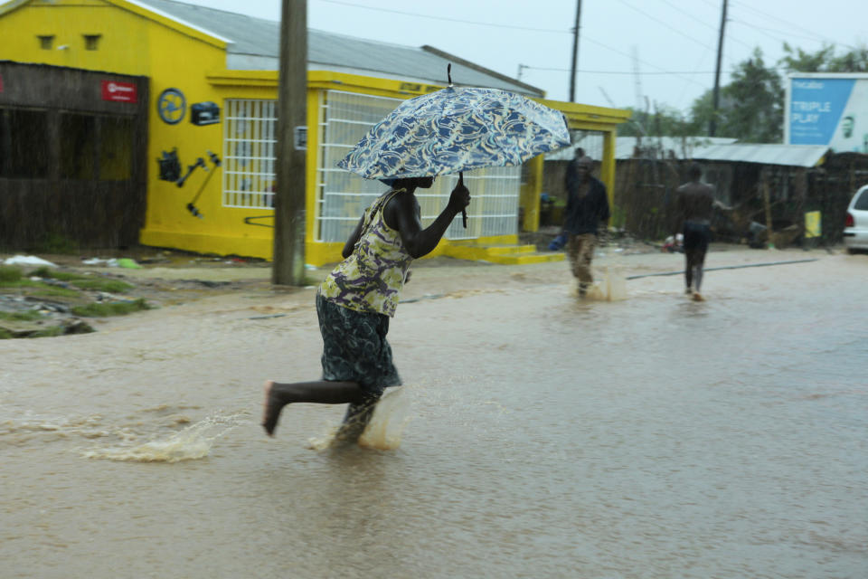 A woman crosses a flooded street, in Natite neighbourhood, in Pemba, on the northeastern coast of Mozambique, Sunday, April, 28, 2019. Serious flooding began on Sunday in parts of northern Mozambique that were hit by Cyclone Kenneth three days ago, with waters waist-high in areas, after the government urged many people to immediately seek higher ground. Hundreds of thousands of people were at risk. (AP Photo/Tsvangirayi Mukwazhi)