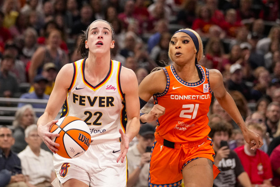 Indiana Fever guard Caitlin Clark (22) shoots in front of Connecticut Sun guard DiJonai Carrington (21) in the second half of a WNBA basketball game in Indianapolis, Monday, May 20, 2024. (AP Photo/Michael Conroy)