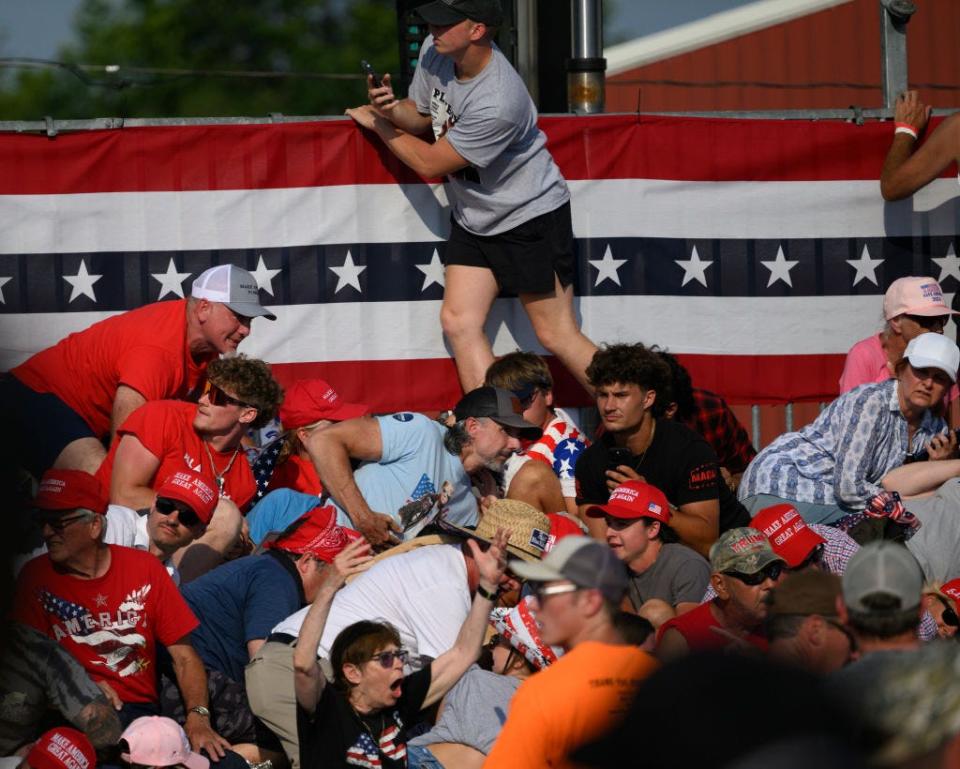Attendees duck from gunfire at a campaign rally for Republican presidential candidate and former U.S. President Donald Trump at the Butler Farm Show Grounds on Saturday.