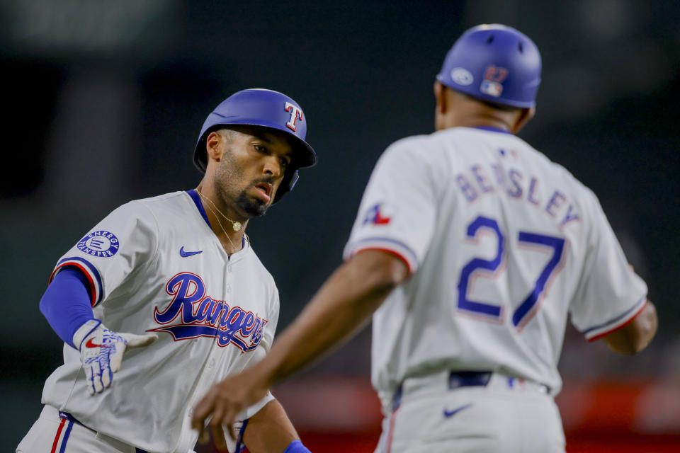 Texas Rangers' Marcus Semien, left, rounds third base and celebrates with third base coach Tony Beasley (27) after hitting a home run during the first inning of a baseball game against the Detroit Tigers, Monday, June 3, 2024, in Arlington, Texas. (AP Photo/Gareth Patterson)