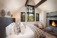 <p>A modern take on a cabin-style bedroom, this beautiful bedroom features a stone fireplace, sheepskin rug, and gray bedding. Design by <a href="https://deringhall.com/interior-designers/aspen-leaf-interiors-inc" rel="nofollow noopener" target="_blank" data-ylk="slk:Aspen Leaf Interiors;elm:context_link;itc:0;sec:content-canvas" class="link ">Aspen Leaf Interiors</a>.</p>