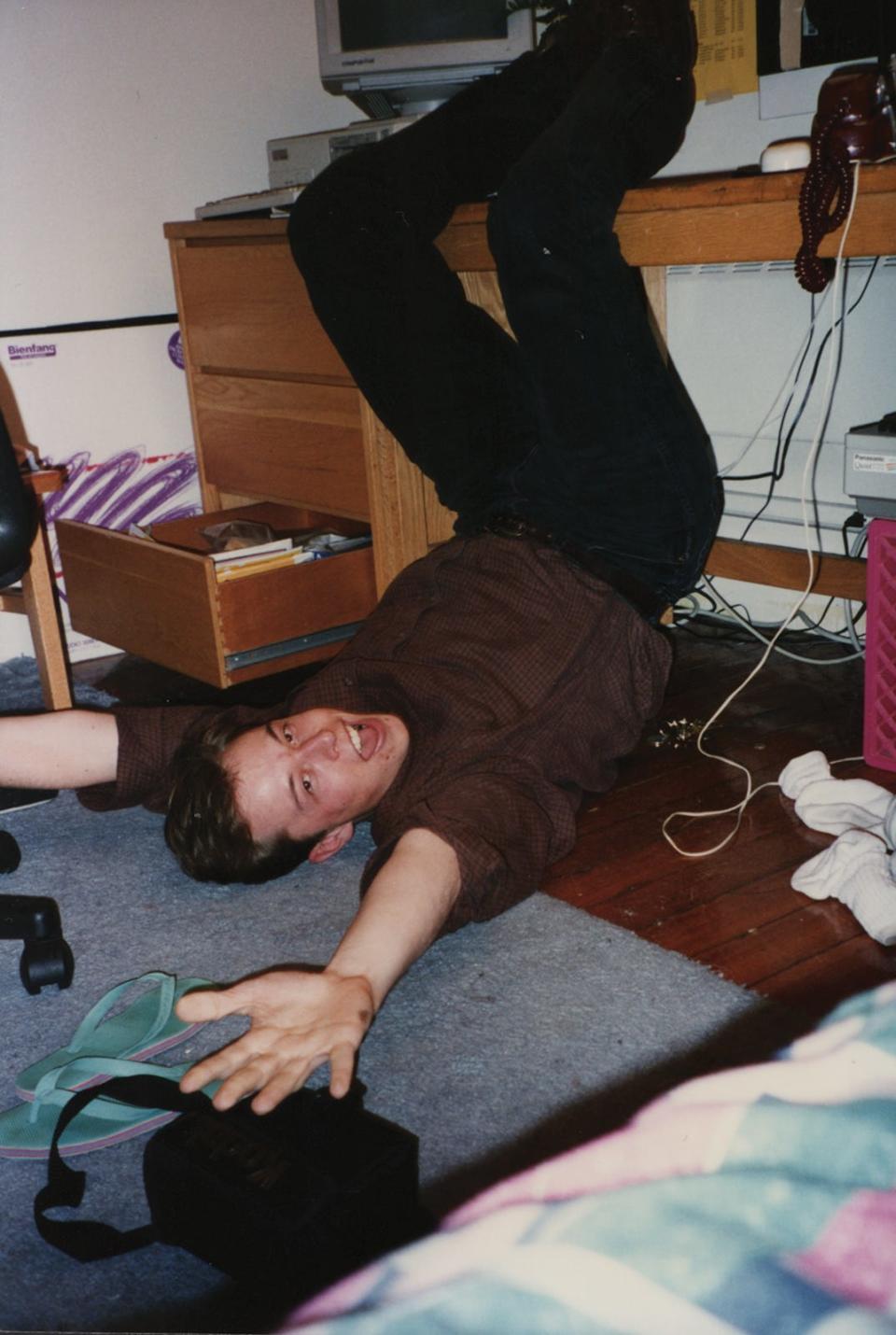 Elon Musk is goofing about upside down on the floor of his girlfriend’s Quadrangle dorm room in 1994.