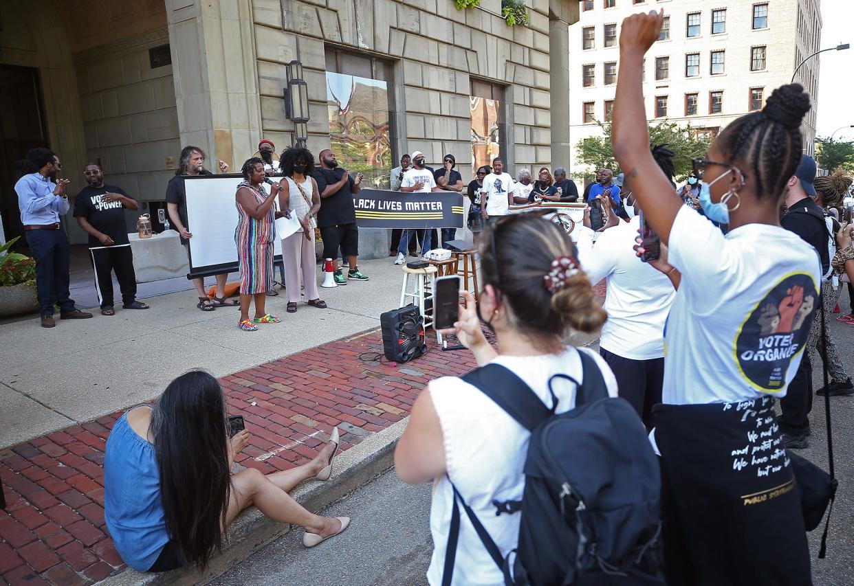 A crowd of around 100 people gather outside Akron City Hall for a rally where a viewing screen has been set up before Monday's virtual City Council meeting.