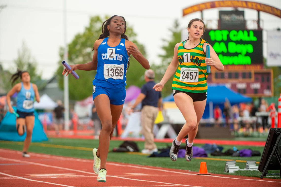 Curtis’ Ava Simms crosses the finish line just ahead of Richland’s Emma Wahlstrom in a heat of the 4A 4x200 relay at the State 2A, 3A, 4A track and field championships on Thursday, May 26, 2022, at Mount Tahoma High School in Tacoma Wash.