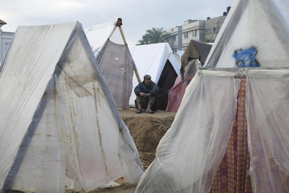 A Palestinian displaced by the Israeli bombardment sits outside a makeshift tent in Rafah, Gaza Strip, Tuesday, Jan. 2, 2023. (AP Photo/Hatem Ali)