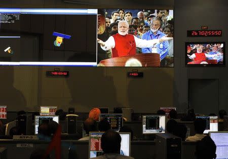 Indian Space Research Organization (ISRO) scientists and engineers watch Prime Minister Narendra Modi (L) on screens after India's Mars orbiter successfully entered at their Spacecraft Control Center in Bangalore September 24, 2014. REUTERS/Abhishek N. Chinnappa